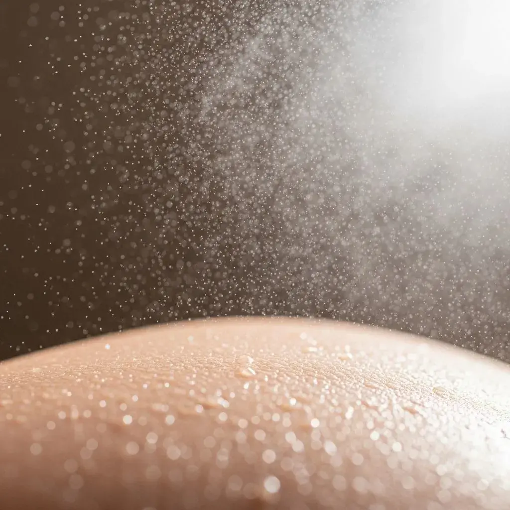 Fine mist setting spray application creating dewy finish on skin